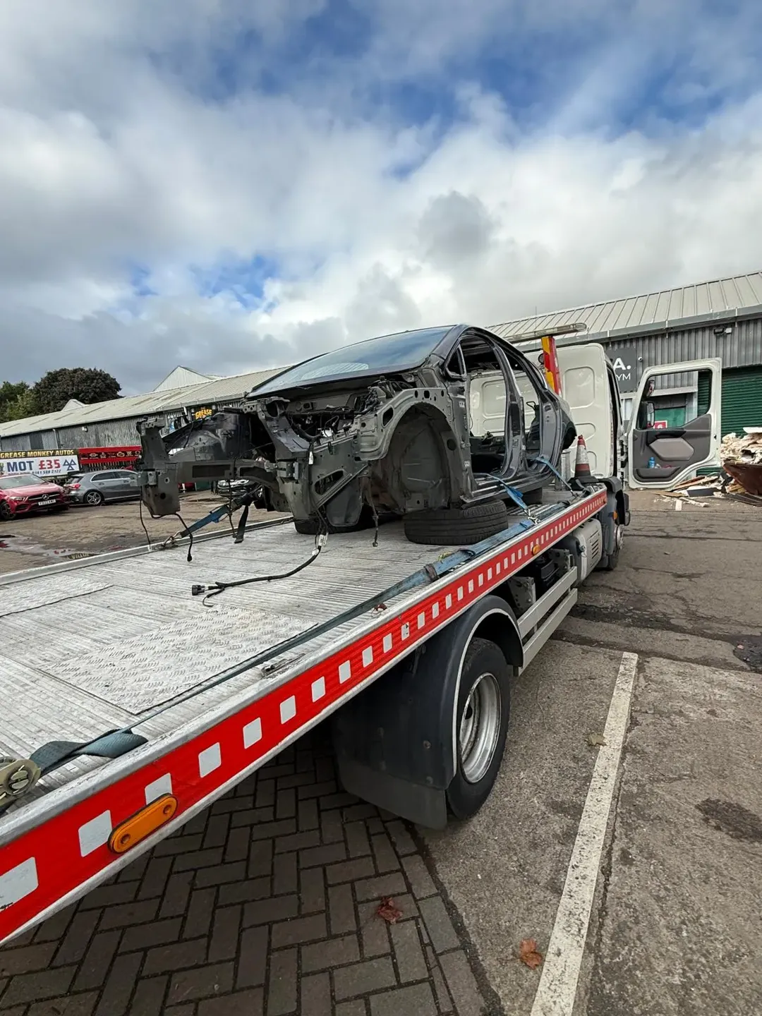 Damaged stripped vehicle shell on recovery truck